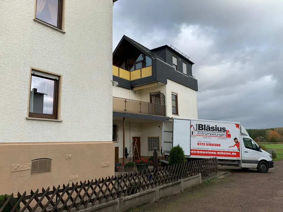 Entrümpelungs-LKW an einem größeren Wohnhaus als Beispiel für Einsätze in Bad Neuenahr-Ahrweiler und seinen Stadtteilen